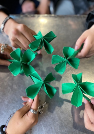 Participantes en el taller de origami: elabora un Shamrock irlandés. 